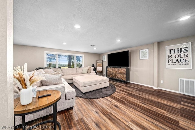 living room featuring a textured ceiling and dark wood-type flooring