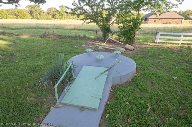 view of storm shelter with a rural view and a yard