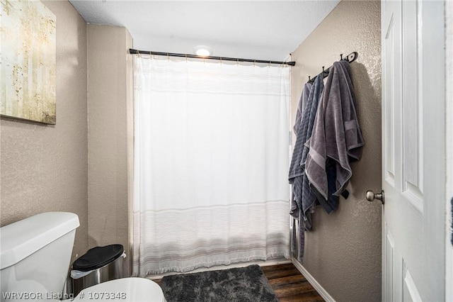 bathroom with hardwood / wood-style flooring and toilet