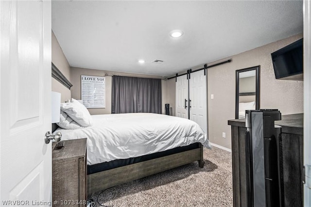 carpeted bedroom with a barn door