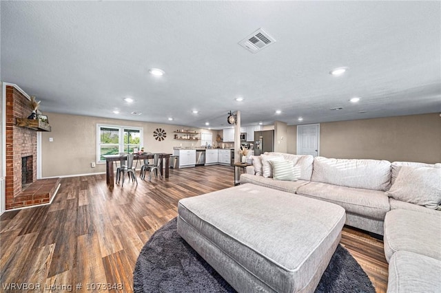 living room with dark hardwood / wood-style floors and a brick fireplace