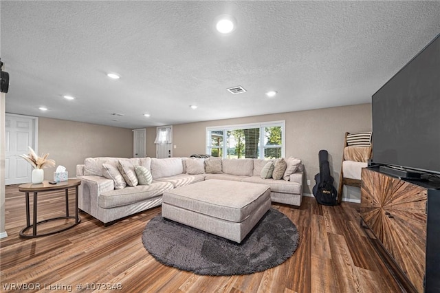 living room with a textured ceiling and hardwood / wood-style flooring