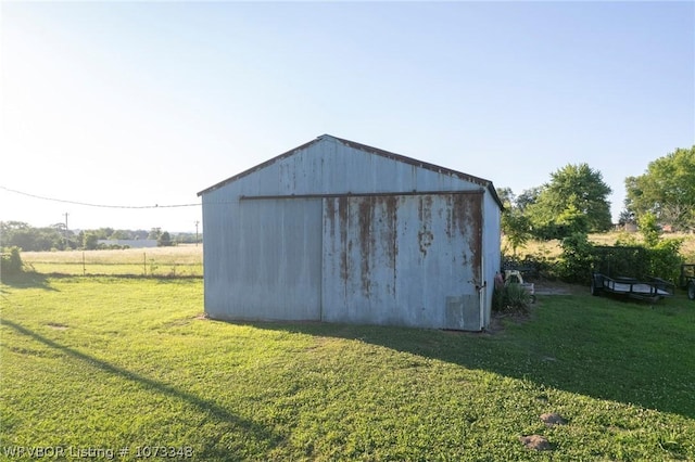 view of outdoor structure with a rural view and a yard