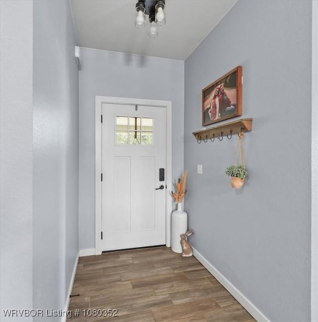 doorway with wood finished floors and baseboards