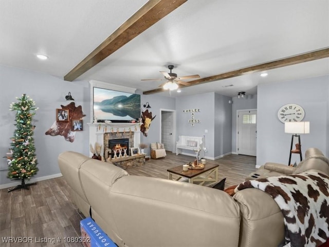 living room with wood finished floors, beam ceiling, baseboards, a fireplace, and ceiling fan