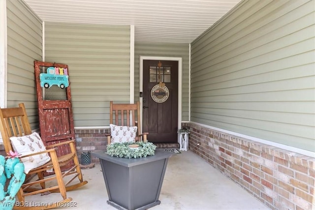 view of exterior entry featuring covered porch