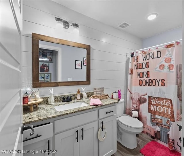 full bath featuring curtained shower, wood finished floors, visible vents, toilet, and vanity