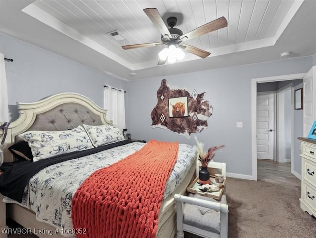 bedroom featuring ceiling fan, carpet, baseboards, visible vents, and a raised ceiling
