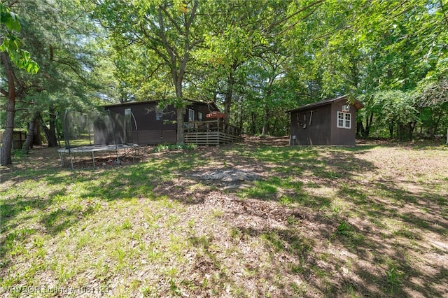 175 Sulphur City Rd, Fayetteville, AR 72701 - view of grassy yard with a trampoline and a wooden deck
