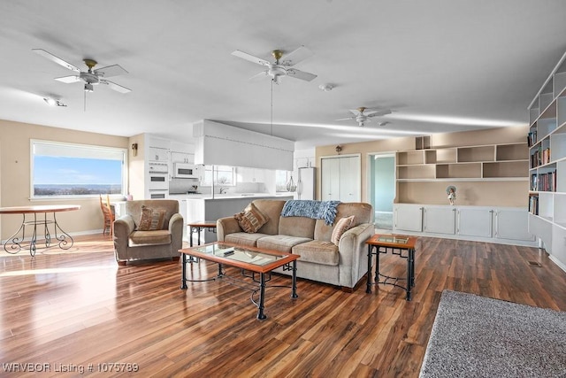 living room featuring ceiling fan and dark hardwood / wood-style floors