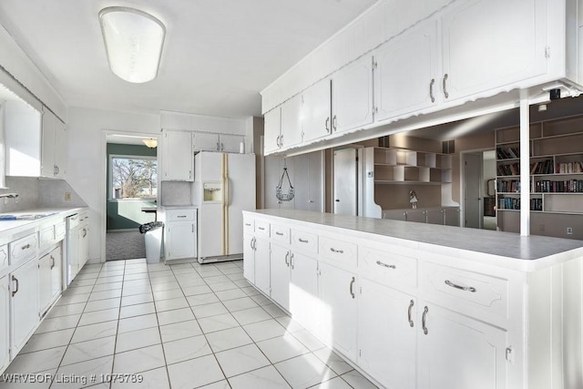 kitchen featuring light tile patterned floors, white cabinetry, tasteful backsplash, white appliances, and sink