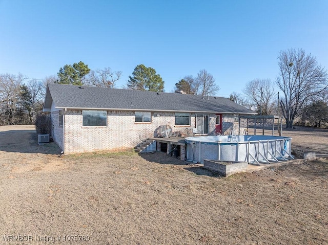 back of property with cooling unit and a lawn