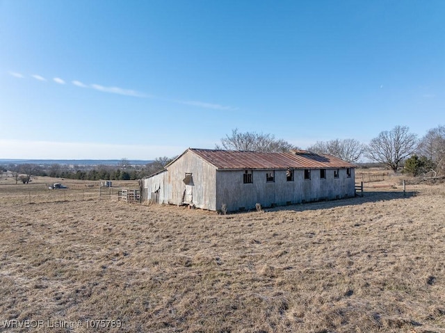 view of side of property with a rural view and an outdoor structure