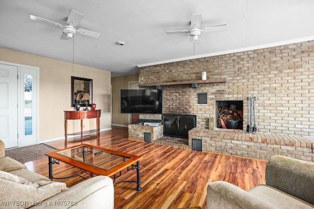 living room featuring ceiling fan, a brick fireplace, and hardwood / wood-style floors