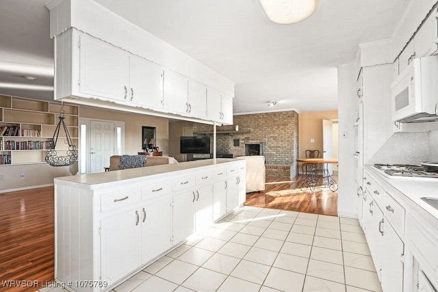 kitchen featuring light tile patterned floors, white cabinetry, and gas stovetop