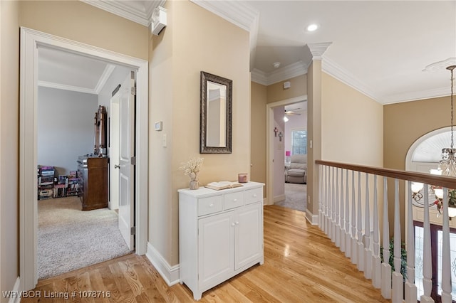 hallway featuring ornamental molding, a chandelier, and light hardwood / wood-style flooring