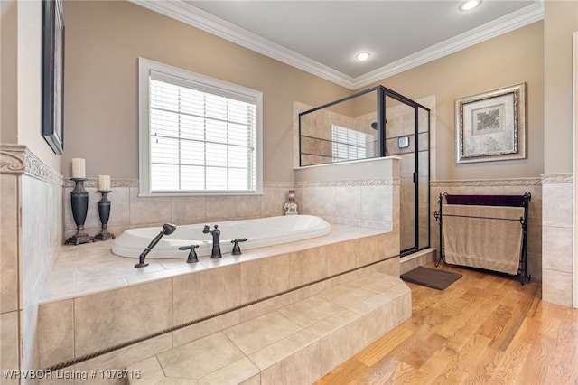 bathroom featuring tile walls, wood-type flooring, ornamental molding, and shower with separate bathtub