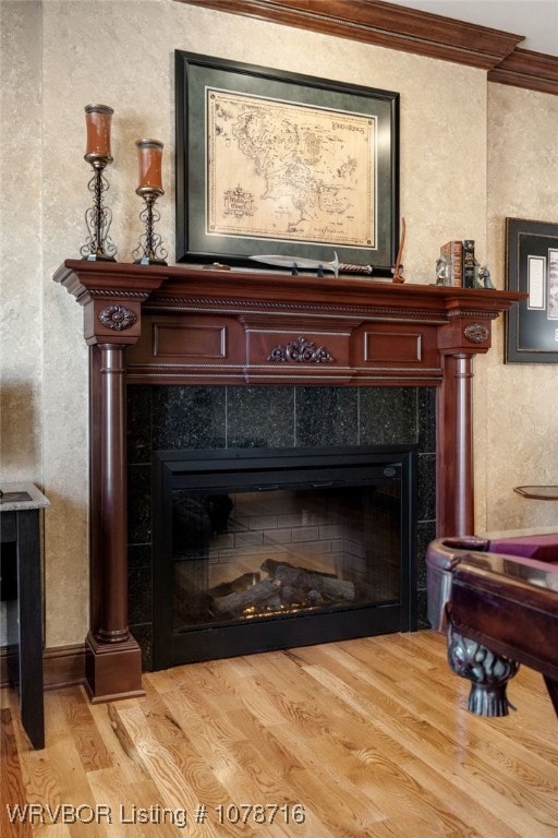 details with hardwood / wood-style flooring, a tile fireplace, and ornamental molding