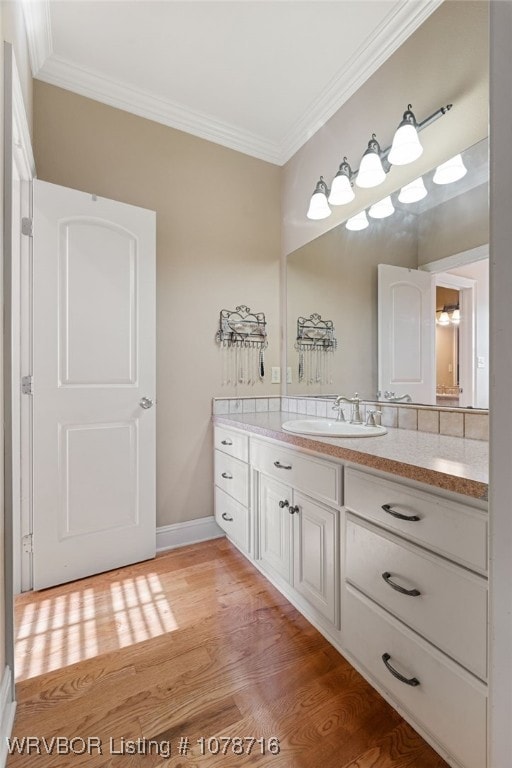 bathroom featuring vanity, hardwood / wood-style floors, and ornamental molding