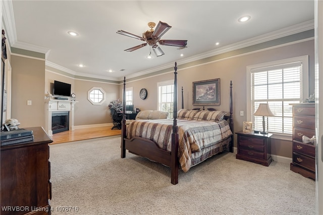 bedroom featuring multiple windows, crown molding, light carpet, and ceiling fan