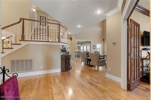 interior space with wood-type flooring, high vaulted ceiling, and a notable chandelier