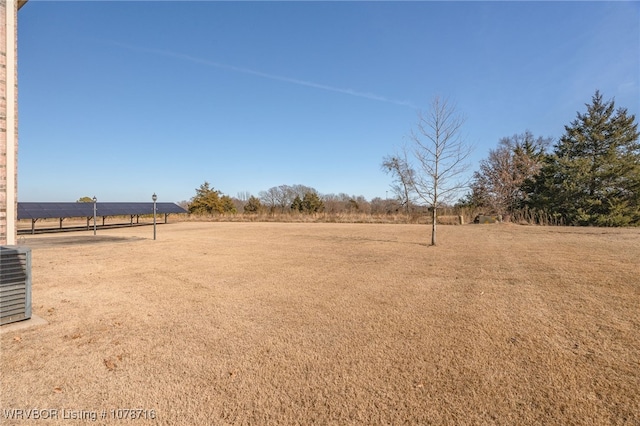 view of yard featuring a rural view and central AC