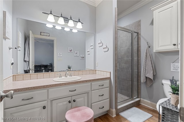 bathroom with vanity, toilet, a shower with door, and hardwood / wood-style floors