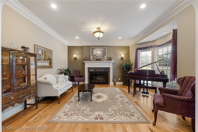 sitting room with ornamental molding, a fireplace, and light hardwood / wood-style floors