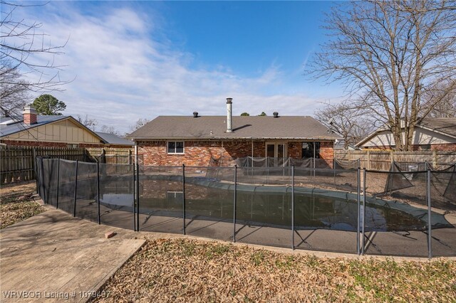 view of swimming pool featuring a covered pool, a fenced backyard, and a patio area