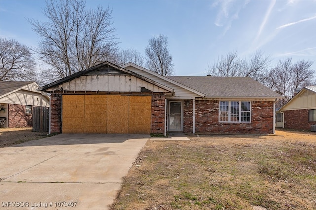 ranch-style house featuring brick siding, an attached garage, concrete driveway, and a shingled roof