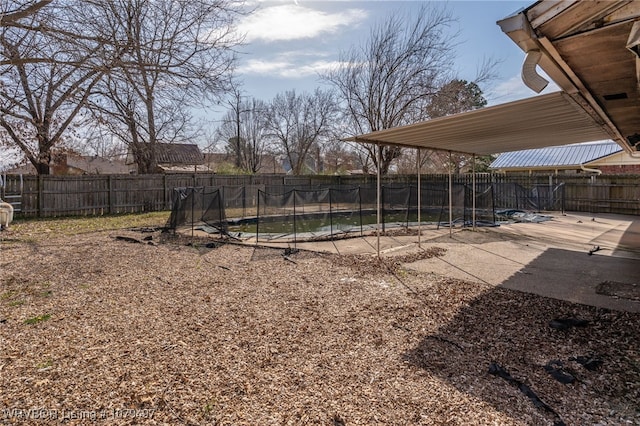 view of yard with a trampoline, a patio area, and a fenced backyard