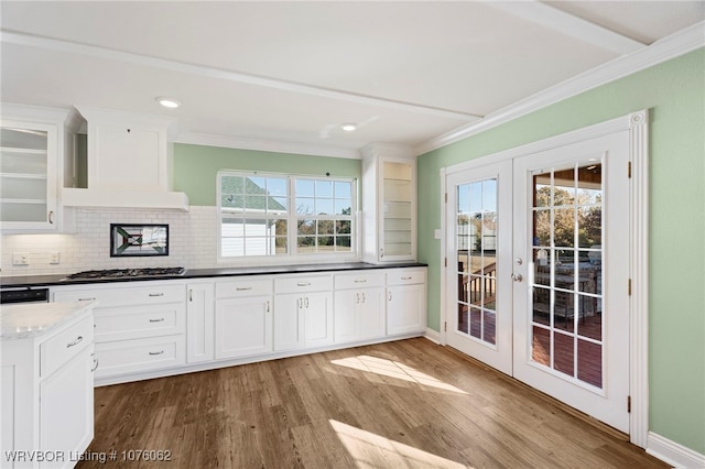 kitchen featuring backsplash, french doors, custom range hood, light hardwood / wood-style floors, and white cabinetry