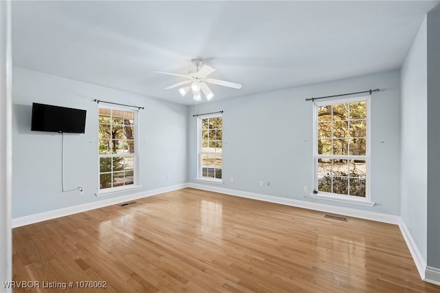 spare room with ceiling fan, light hardwood / wood-style flooring, and a healthy amount of sunlight