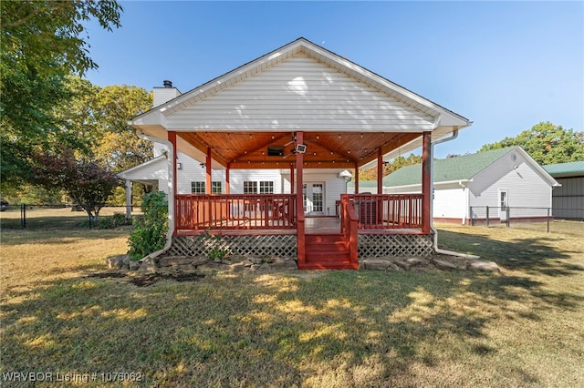 rear view of property with a deck and a yard