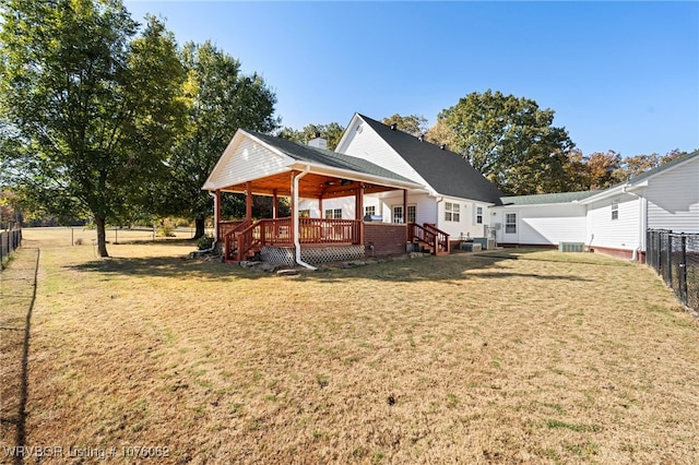 back of property featuring a deck and a lawn