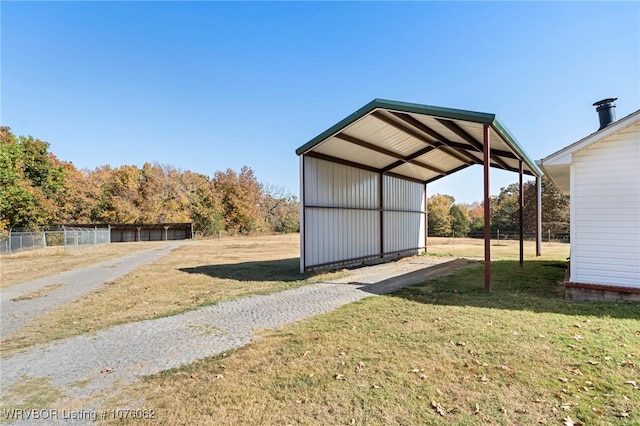 view of outdoor structure with a lawn and a carport