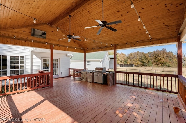 wooden terrace with ceiling fan and area for grilling