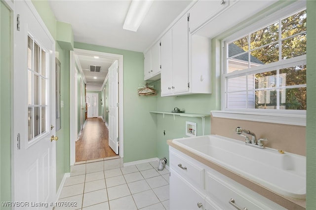 laundry area with washer hookup, cabinets, light tile patterned floors, and sink