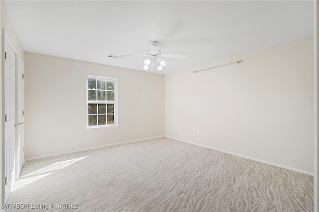 carpeted spare room featuring ceiling fan