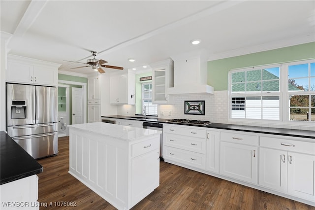 kitchen with custom exhaust hood, a center island, a wealth of natural light, appliances with stainless steel finishes, and white cabinetry