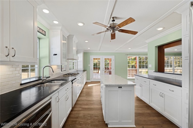 kitchen featuring dark hardwood / wood-style floors, a kitchen island, white cabinetry, and sink