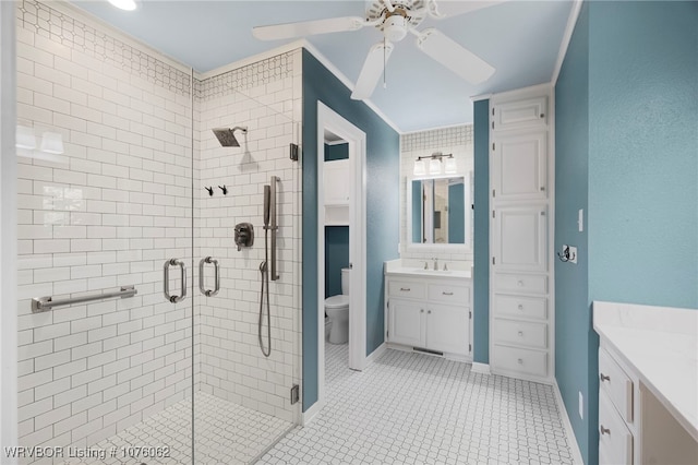 bathroom with ornamental molding, vanity, a shower with door, ceiling fan, and toilet