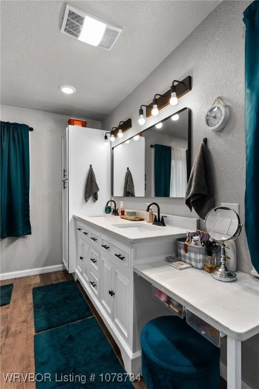 bathroom featuring a textured ceiling, wood-type flooring, and vanity