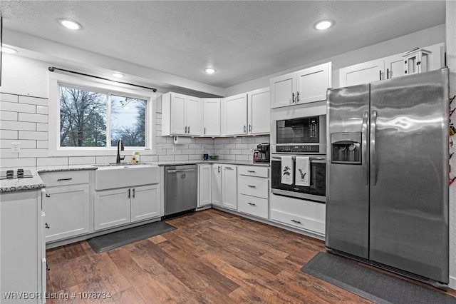 kitchen featuring appliances with stainless steel finishes, white cabinets, and light stone countertops