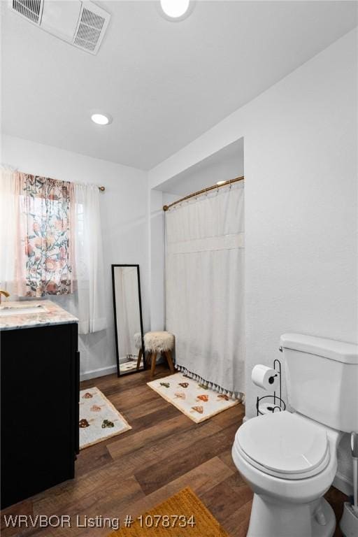 bathroom featuring wood-type flooring, vanity, a shower with curtain, and toilet