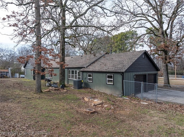 view of front of property featuring central air condition unit and a garage