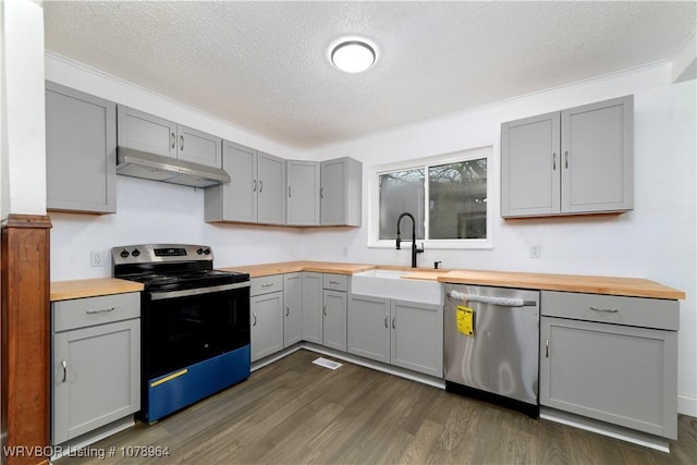 kitchen featuring appliances with stainless steel finishes, sink, gray cabinetry, and wooden counters