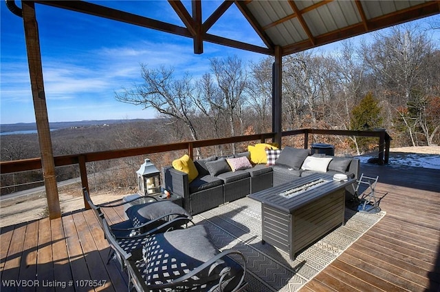 wooden terrace featuring an outdoor living space with a fire pit