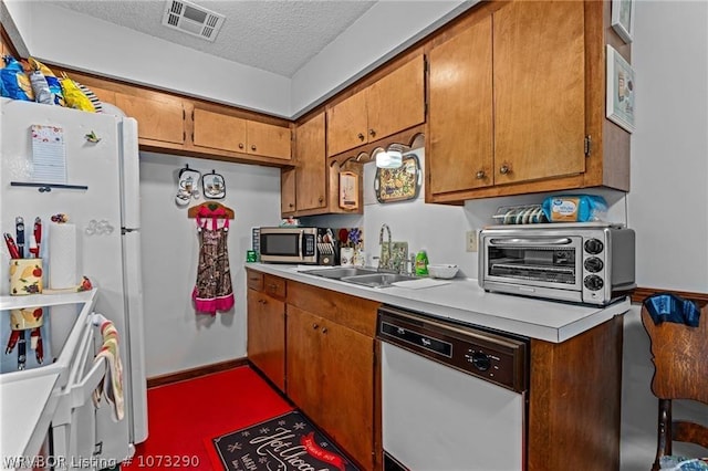 kitchen featuring a textured ceiling, white dishwasher, and sink