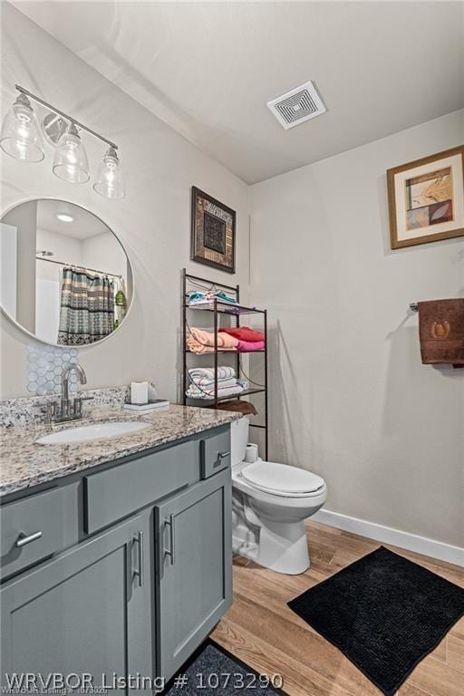 bathroom featuring vanity, wood-type flooring, and toilet